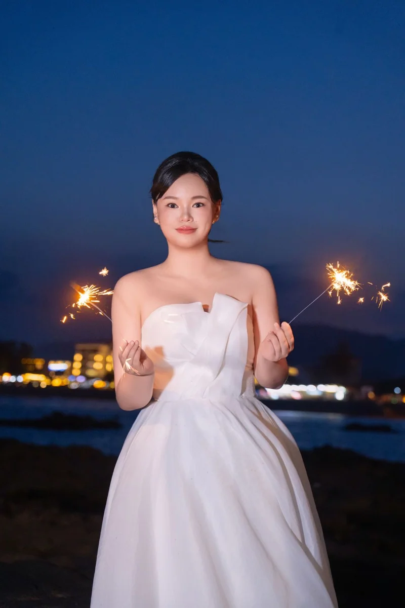 夜色中手持两支仙女棒的新娘